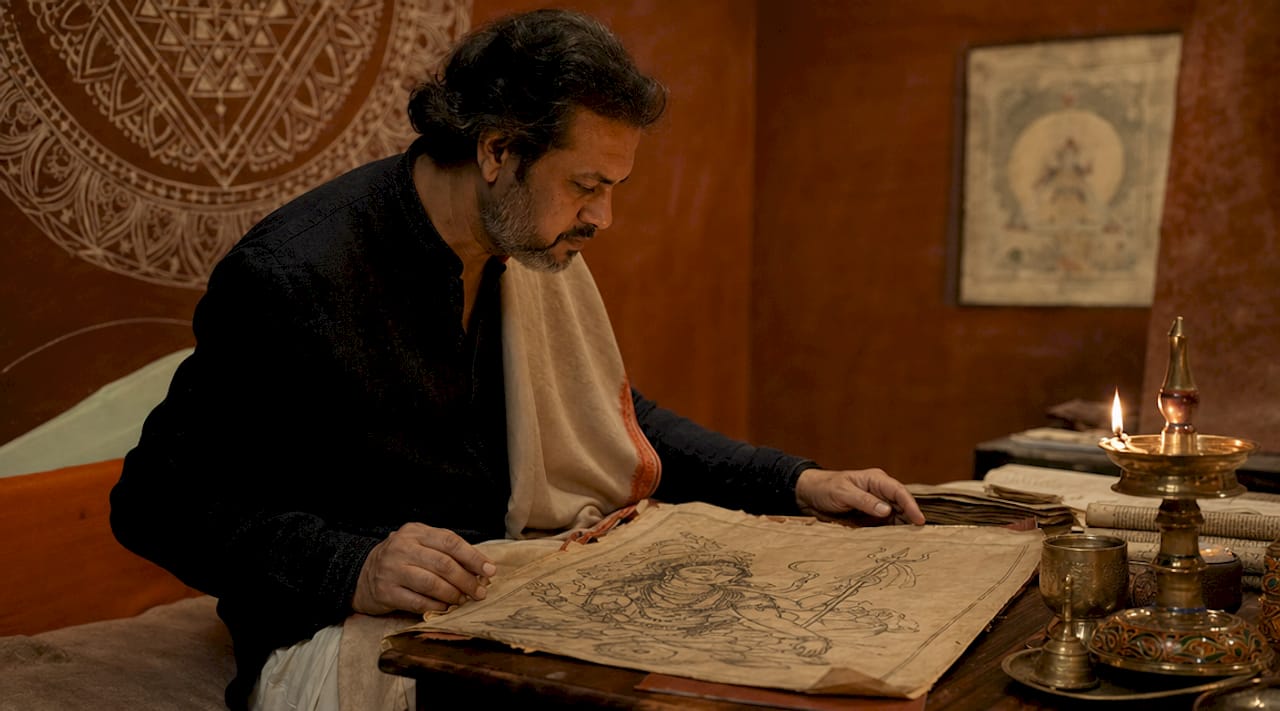 Scholar studying Shiva iconography manuscript
