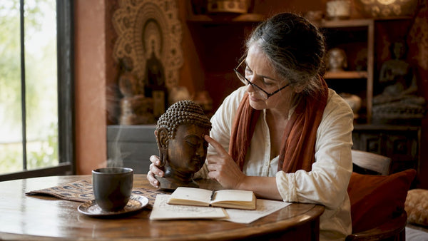 Art historian examining Buddha sculpture urna detail