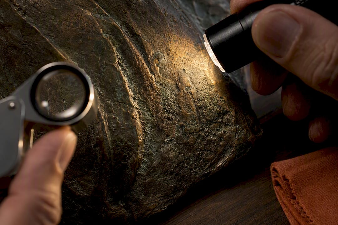 Raking light revealing layered bronze patina